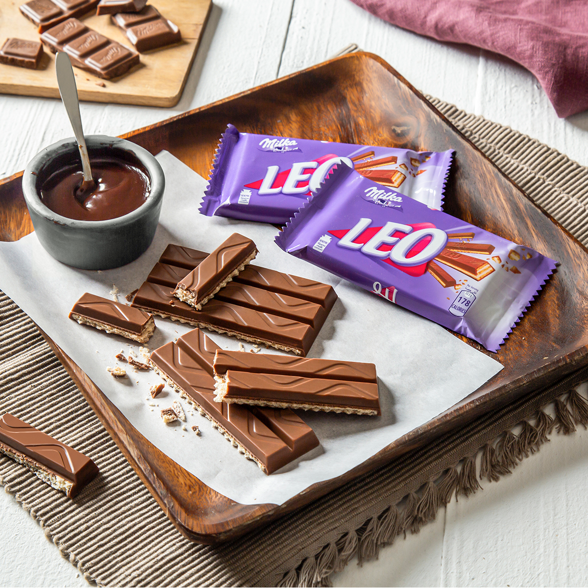 LEO chocolate bars and pieces arranged on white plate with chocolate dipping sauce.