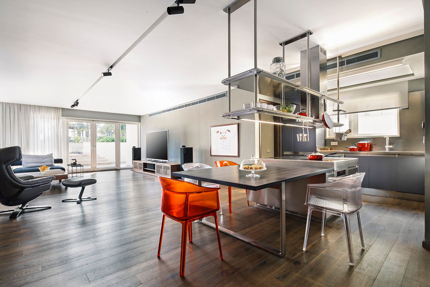 Modern open concept living space with kitchen island and industrial style shelving.