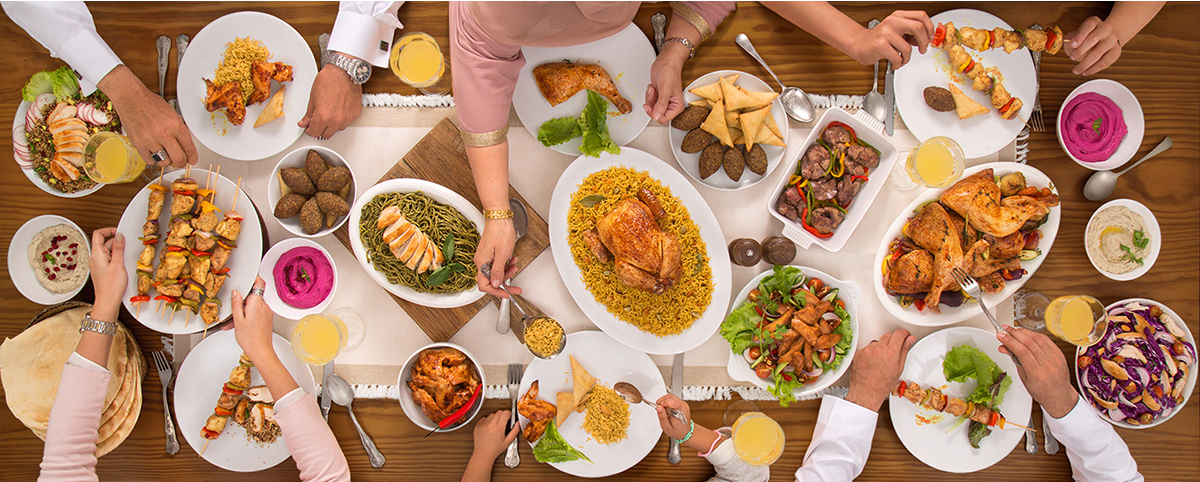 Overhead view of a festive dining table spread with multiple dishes and sharing plates at a family-style meal.