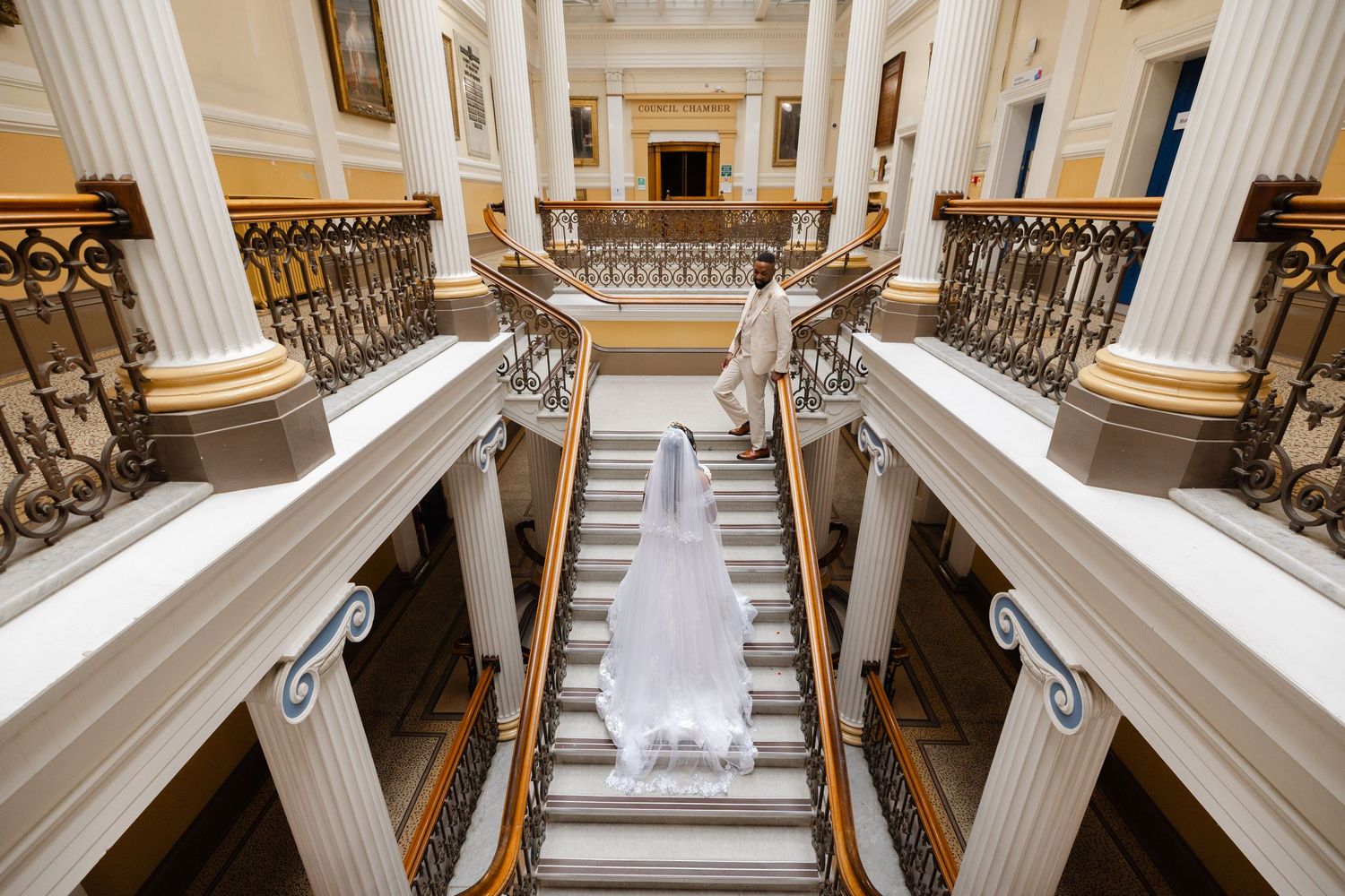 Interior view of grand courthouse with ornate marble columns and staircase showing architectural details.