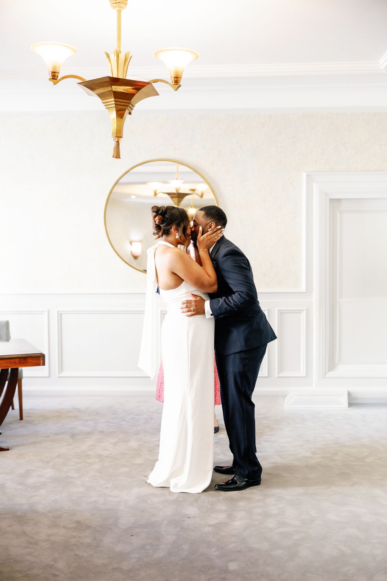 Shelana and Peter’s couple portrait sharing a look on the stairs at their London wedding, captured by Oisin Studios