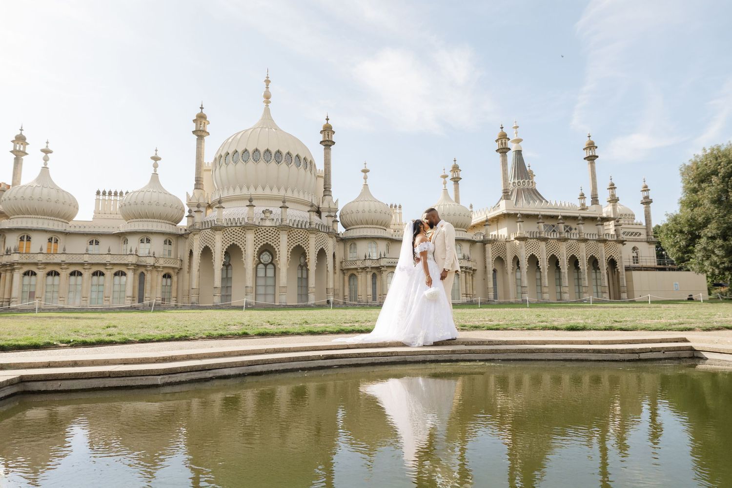 The Royal Pavilion in Brighton reflects majestically in the still waters of its ornate garden pond on a sunny day.