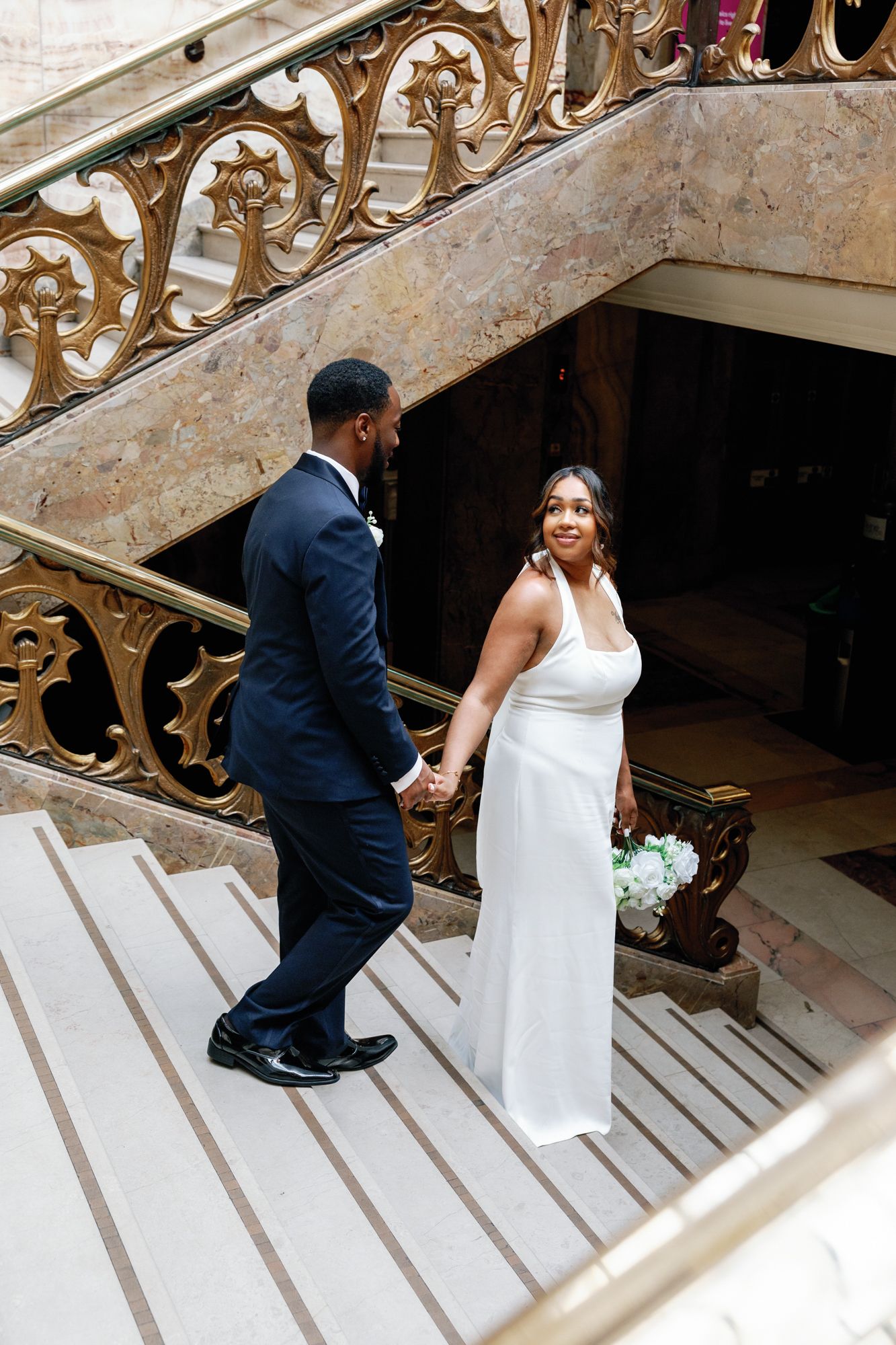 Shelana and Peter’s couple portrait on the stairs with the groom leading at their London wedding, captured by Oisin Studios