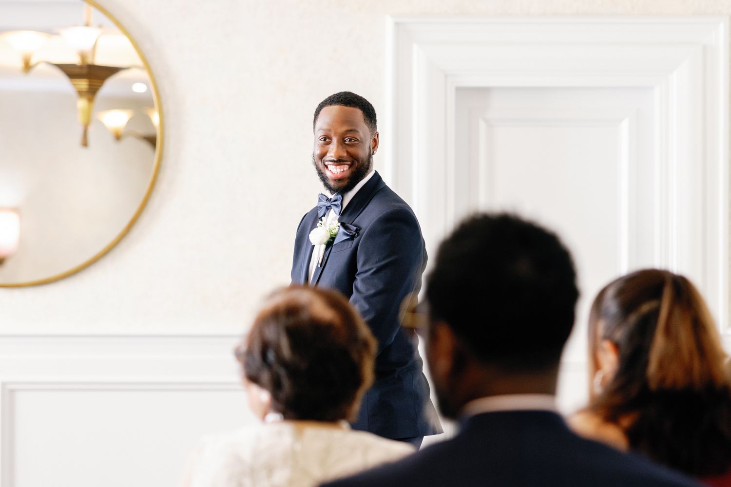 Wedding guests listen attentively Shelana and Peter’s first look at their London wedding captured by Oisin Studios