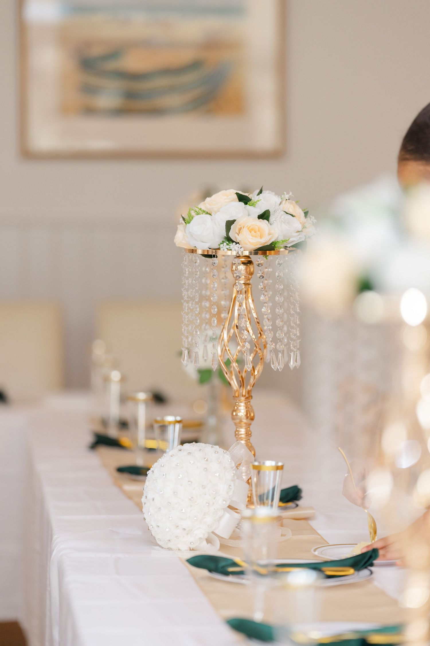Crystal candelabra centerpiece with white hydrangeas and roses on an elegant white tablecloth at a formal wedding reception.