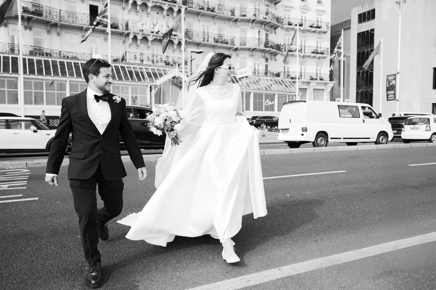 A sequence of black and white wedding photos shows a bride and groom playfully running and posing on a city street.