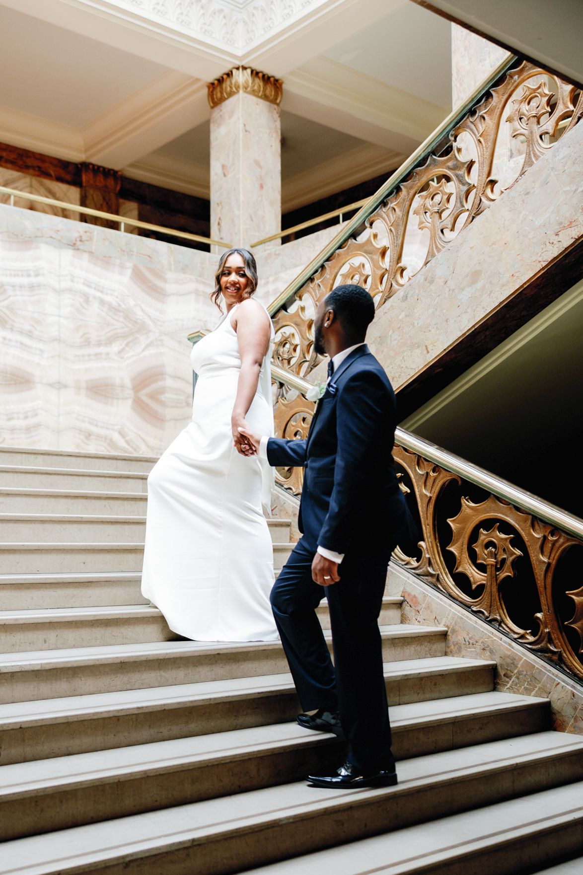 Shelana and Peter’s couple portrait on the stairs at their London wedding, captured by Oisin Studios