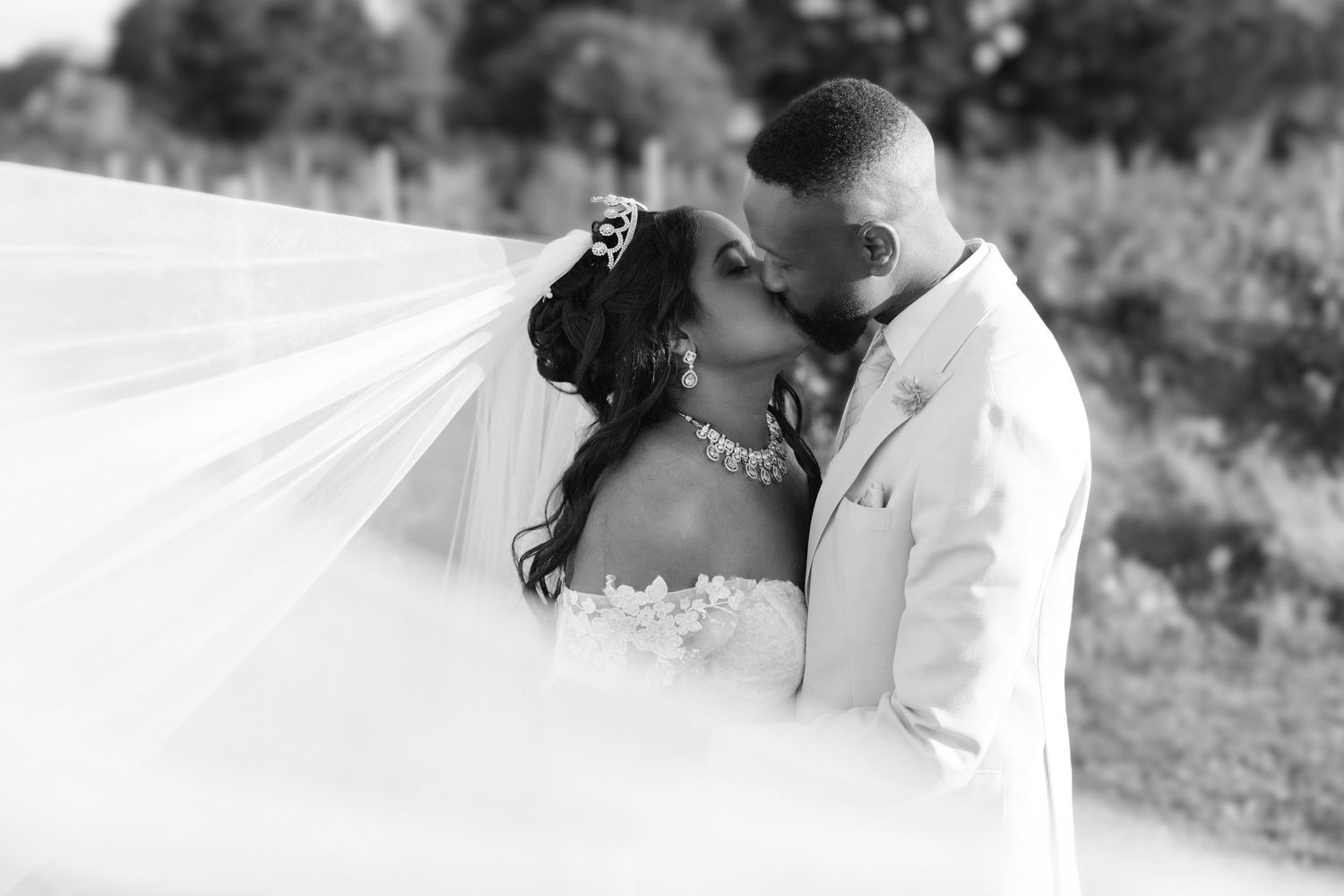 Black and white wedding photo collage showing five intimate moments between newlyweds outdoors.