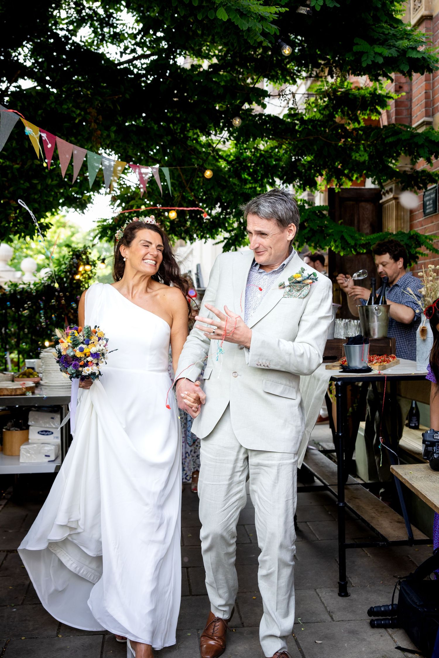 A couple in white attire dance together in a candid sequence of wedding photos captured outdoors.