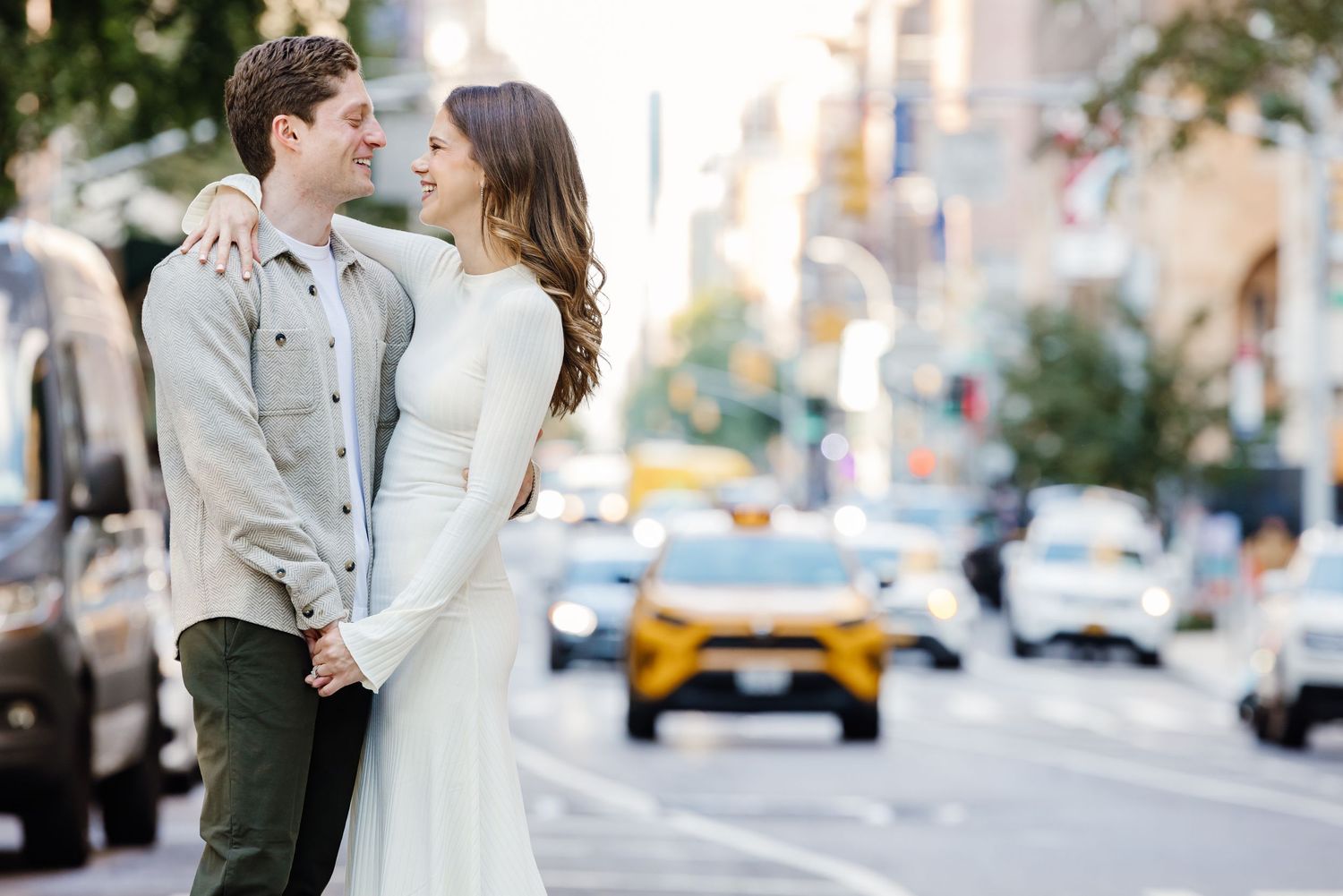 Romantic couple holding hands and gazing at each other on a busy New York City street.