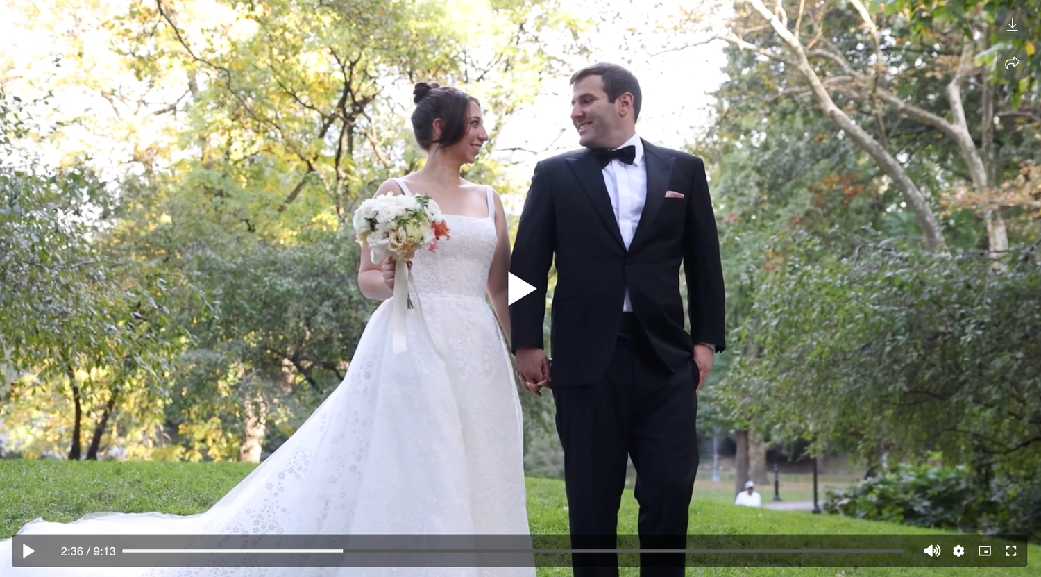 Elegant bride and groom walking hand in hand through lush garden in formal wedding attire.