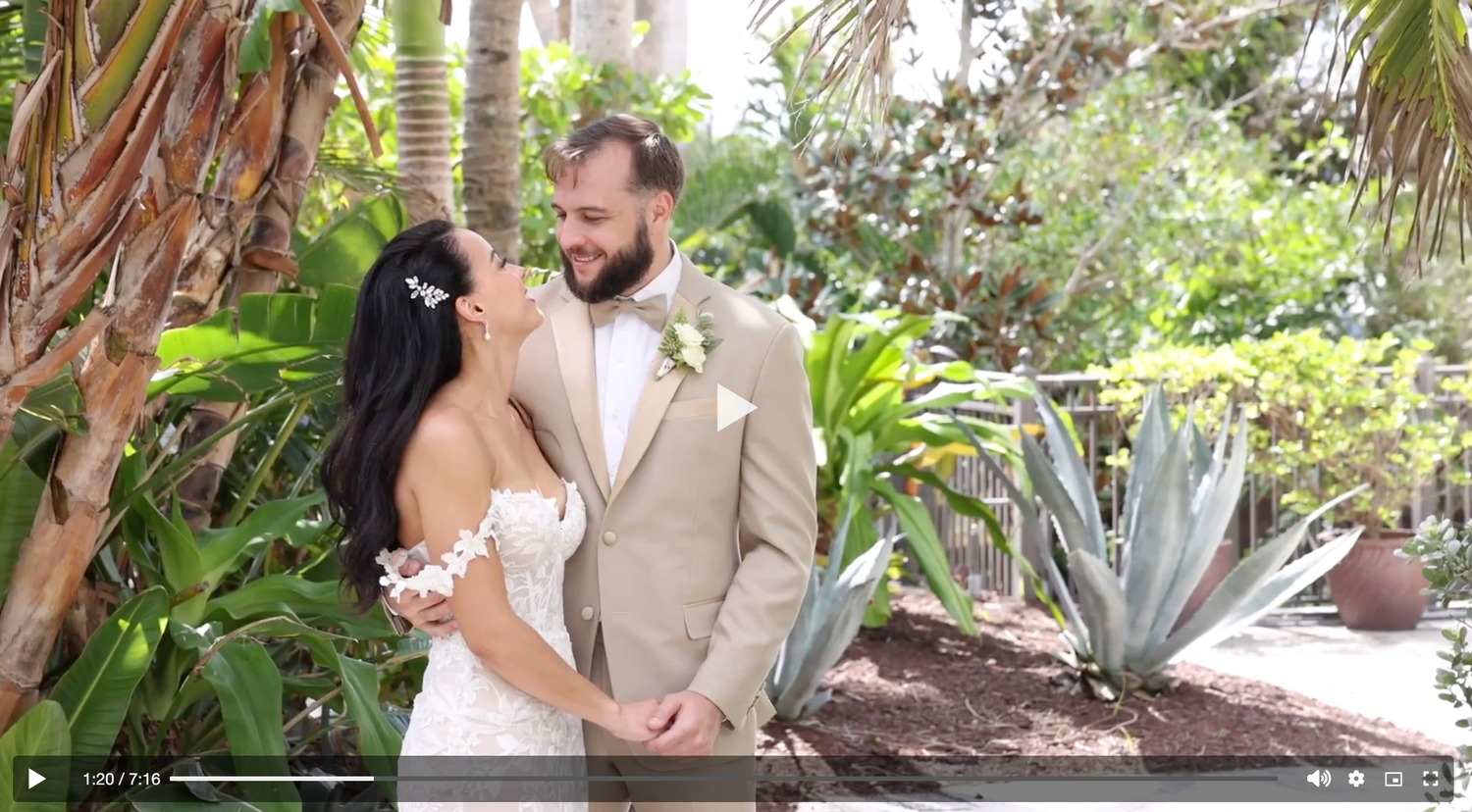 Bride and groom sharing romantic moment in tropical garden setting with agave plants.