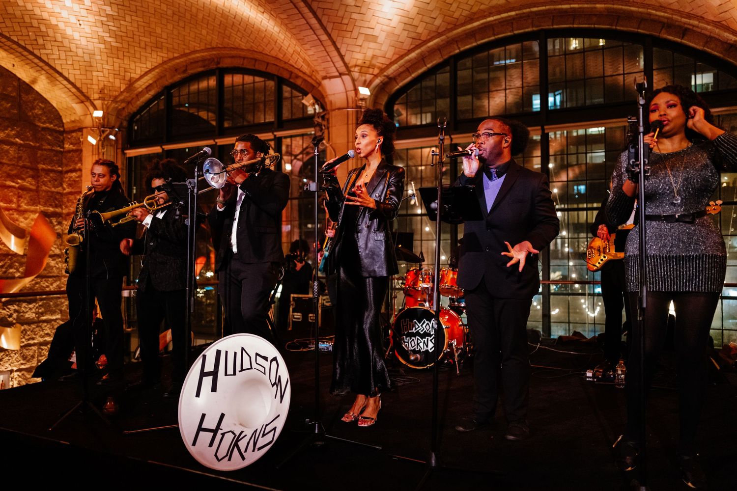Hudson Horns live band performs energetically at a wedding reception under brick arched ceilings.