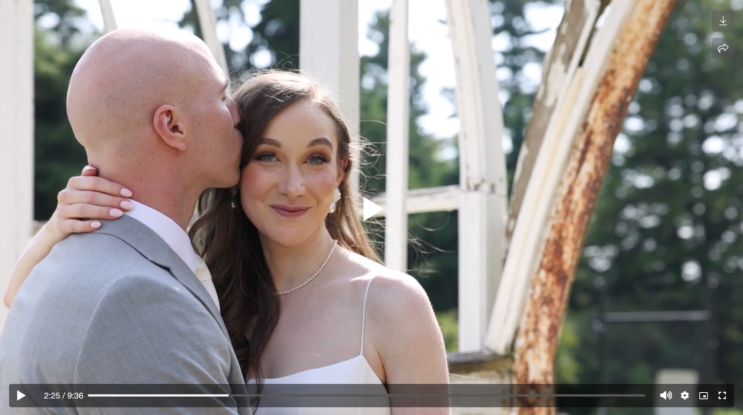 Groom tenderly kissing bride on cheek in elegant greenhouse wedding portrait.