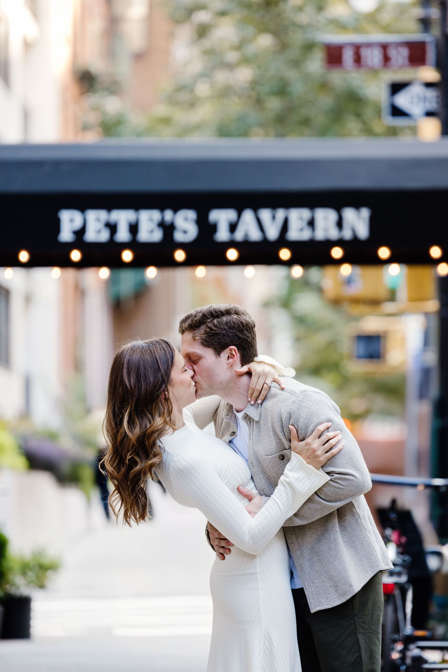 Couple sharing a passionate kiss outside Pete's Tavern on a charming New York City street.