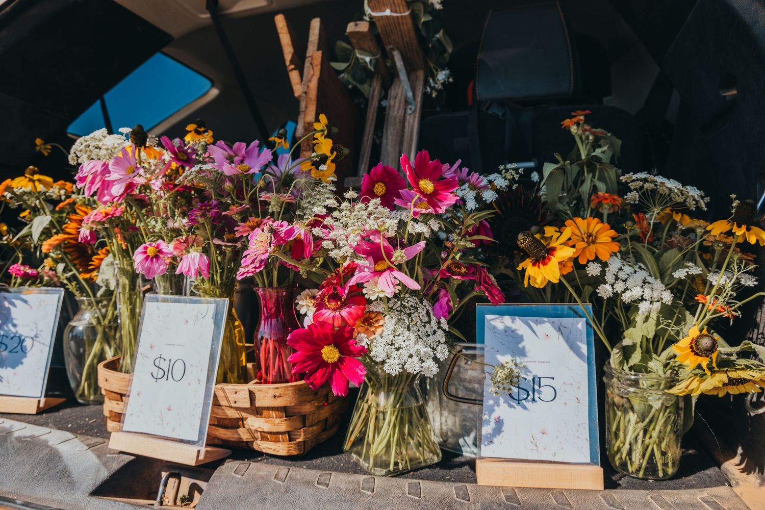 Fresh flower bouquets featuring pink and orange blooms displayed at an outdoor market stall.