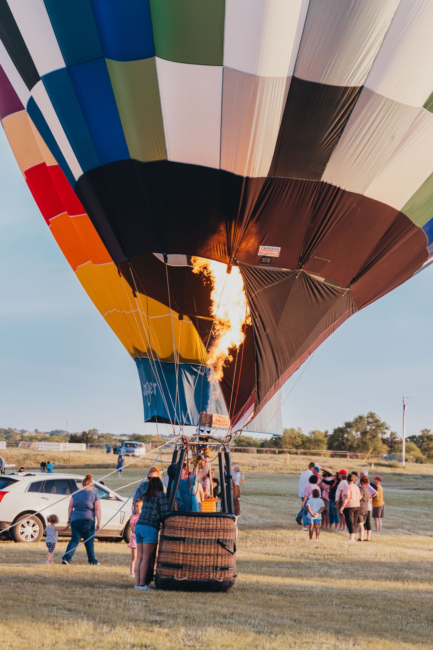 Hot air balloon burner ignites with bright flame during inflation process.