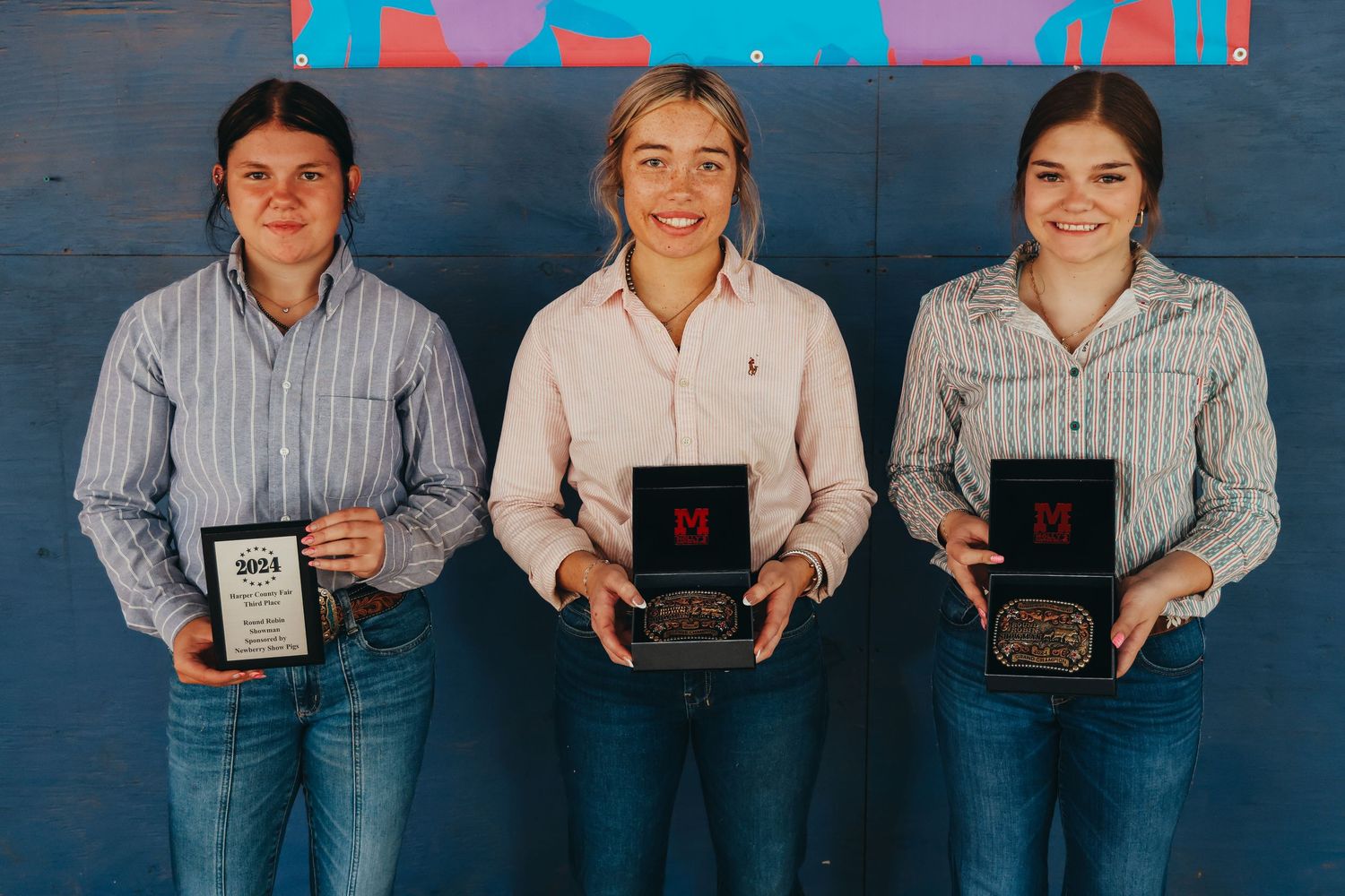 Award winners holding their plaques and trophies against a colorful backdrop.
