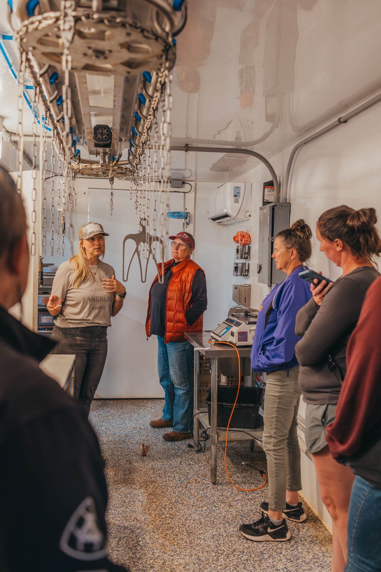 Group touring inside an industrial facility with metal equipment and pipes.