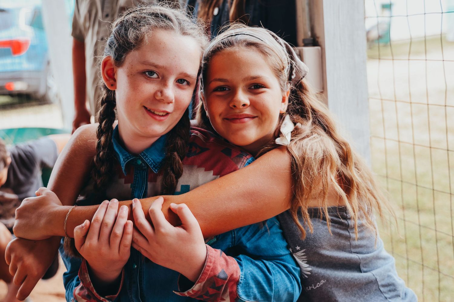 Two young participants hold a small animal together at a county fair event.