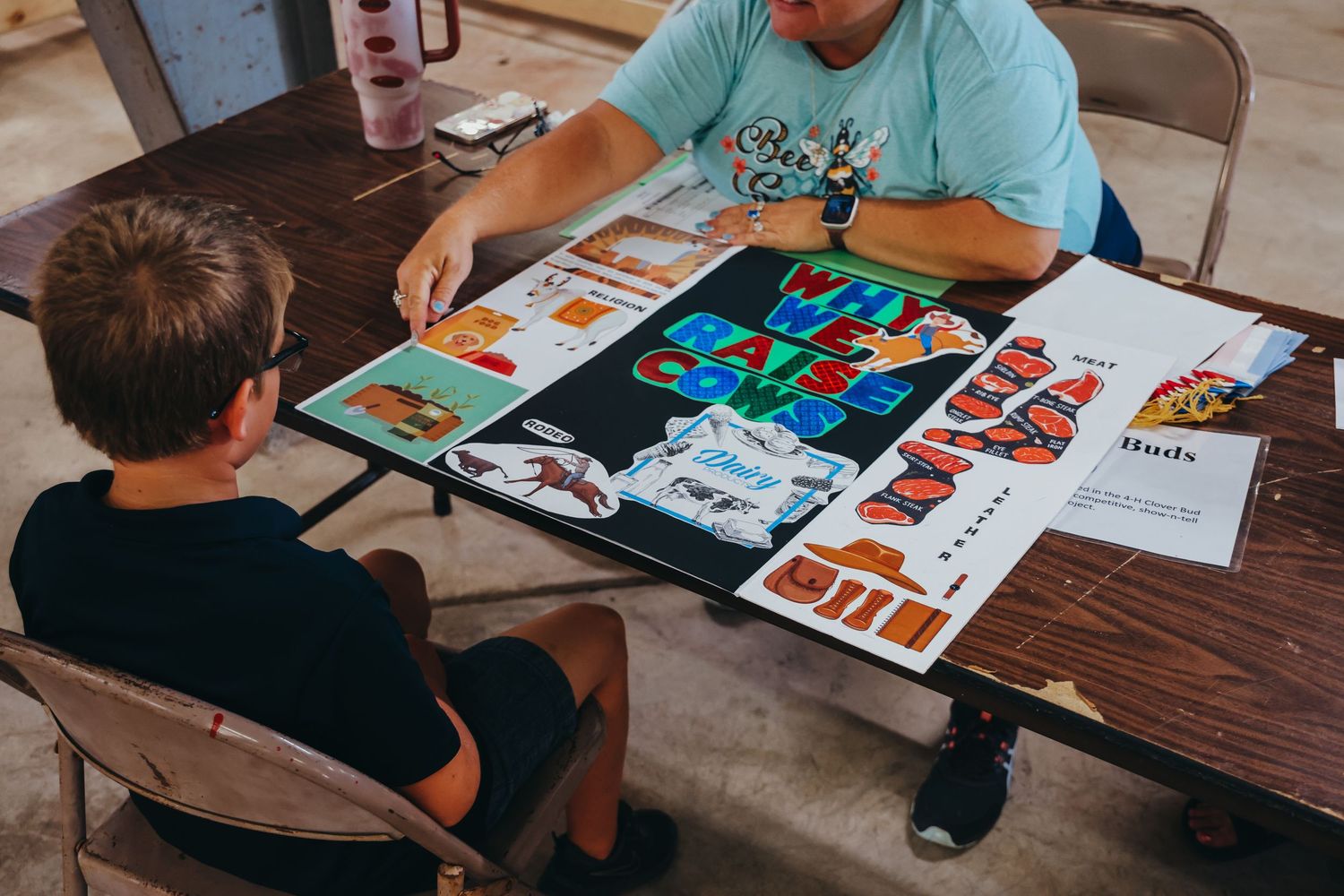 Two people review colorful documents and materials spread across a table.