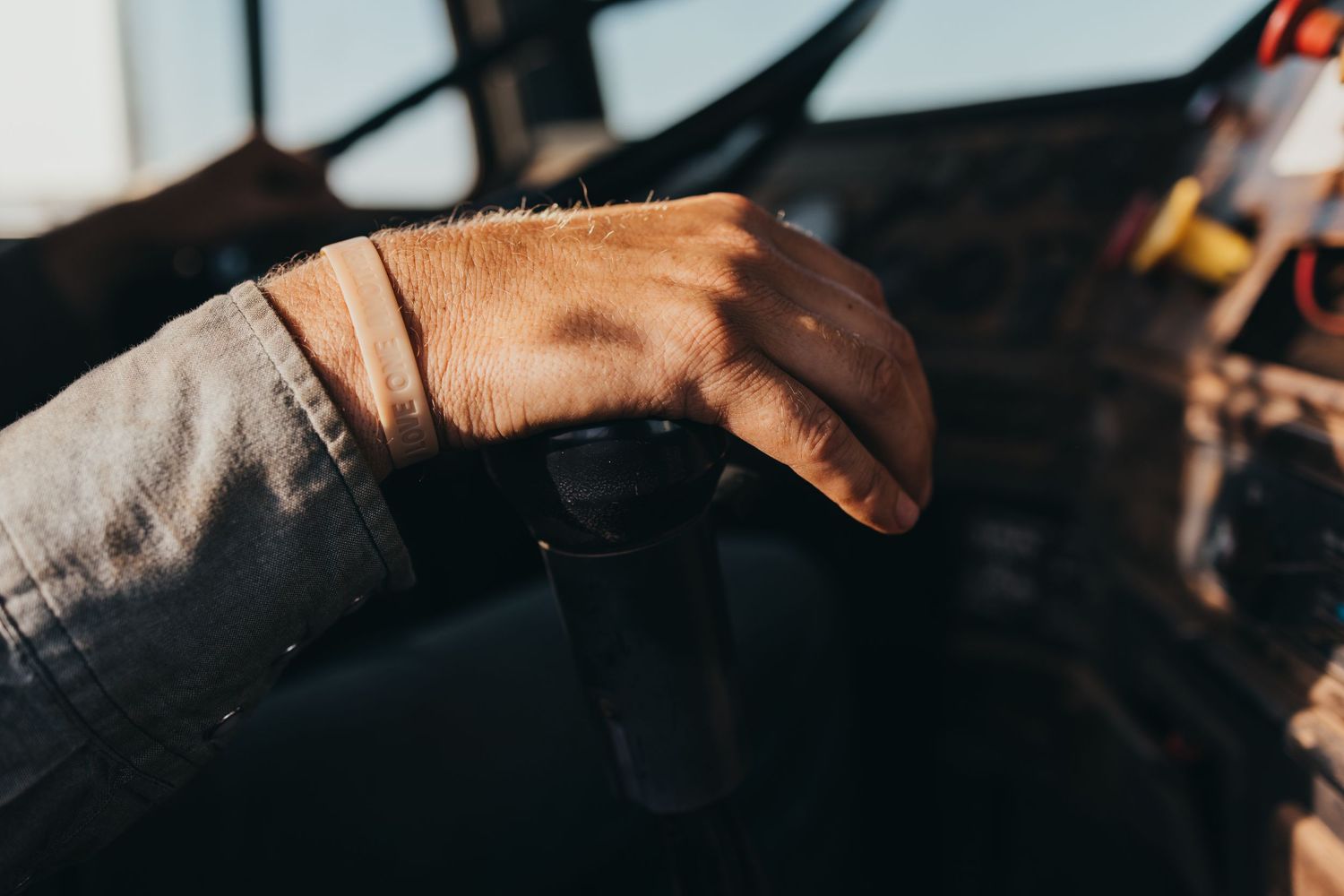 Close-up photo showing several hands touching and connecting in a circle against a dark background.