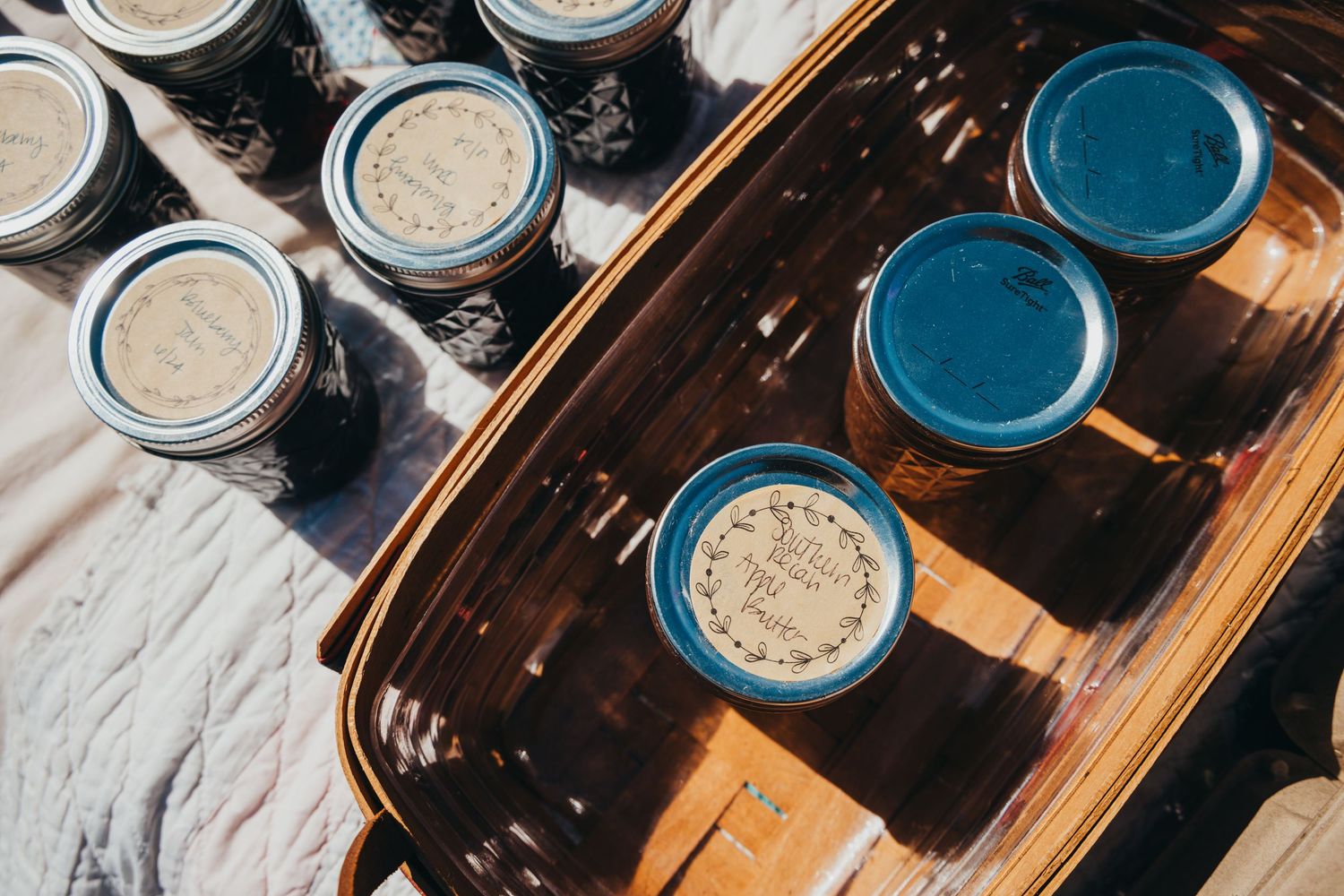 Overhead view of paint cans with blue and silver lids arranged on a dark wooden surface.