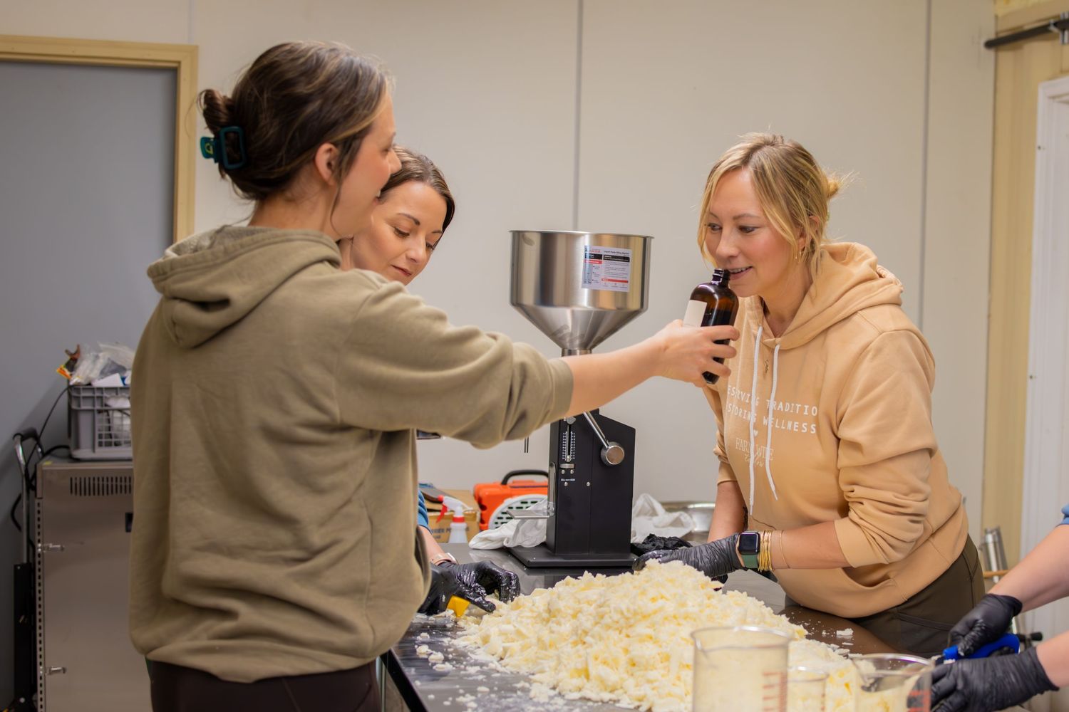 People working together in a casual kitchen setting with shredded ingredients on table.