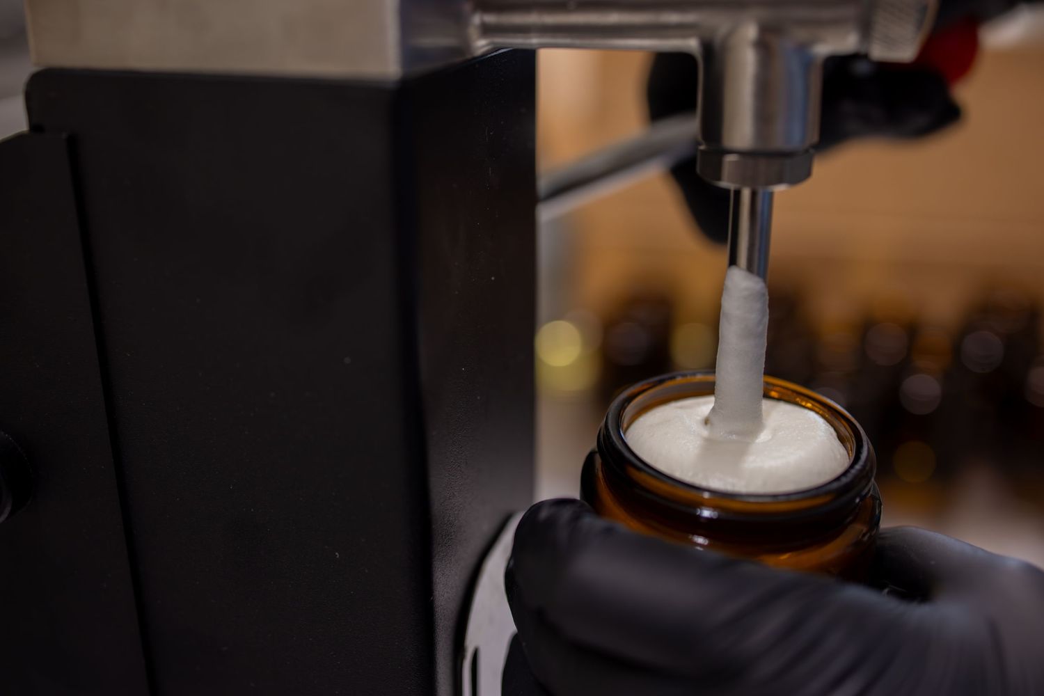 Close-up shot of an espresso machine tamping coffee grounds in a portafilter.