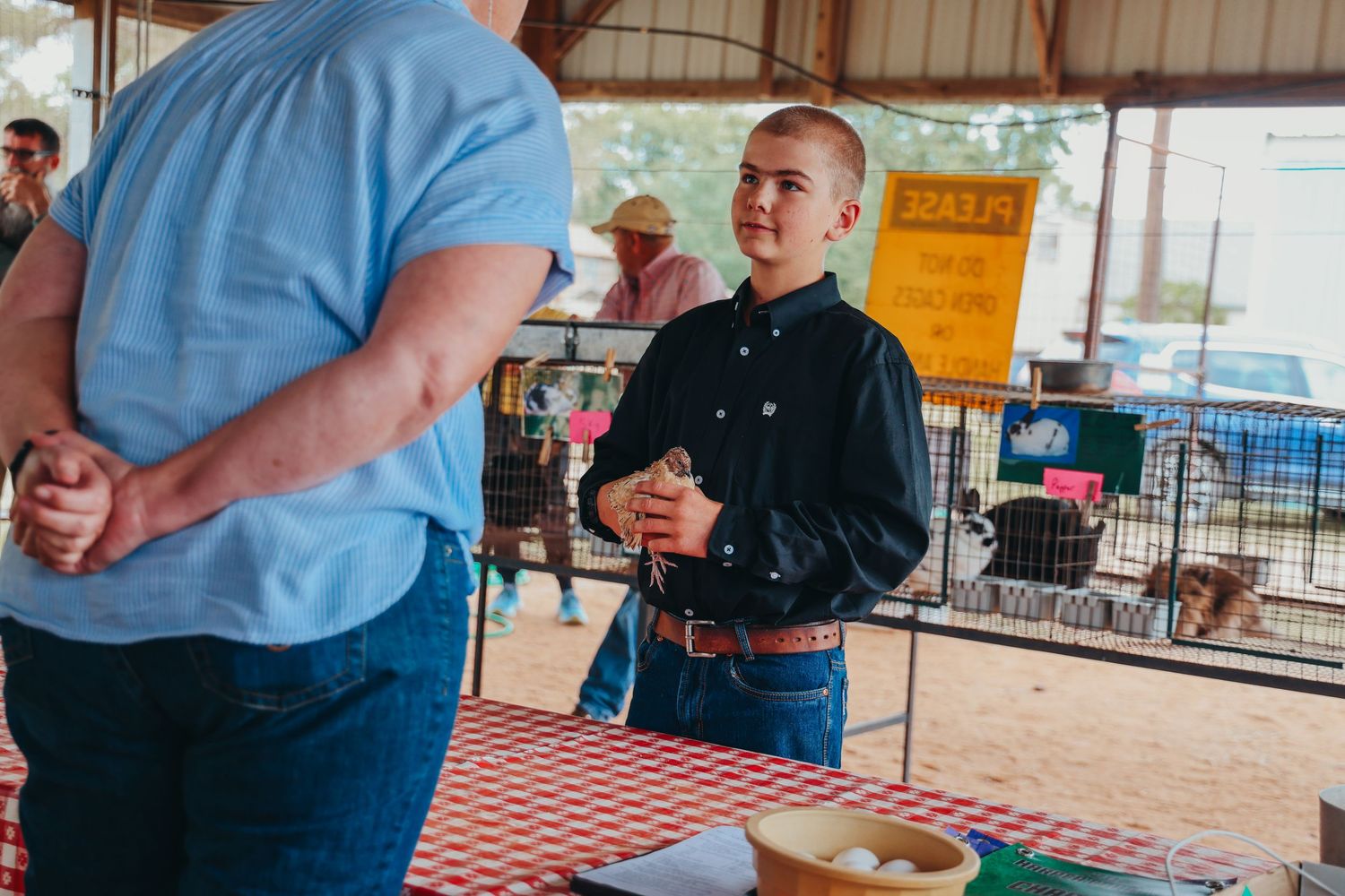 People having a discussion at a covered outdoor venue with tables.