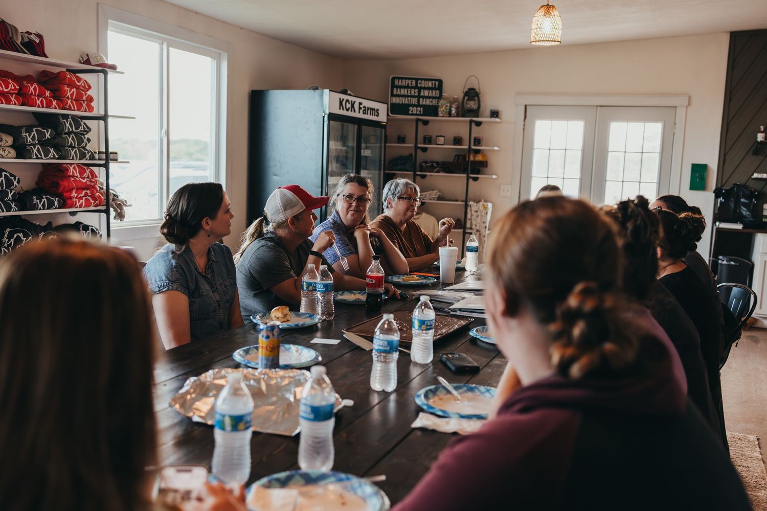 Group gathered around dining table for casual meeting or meal.