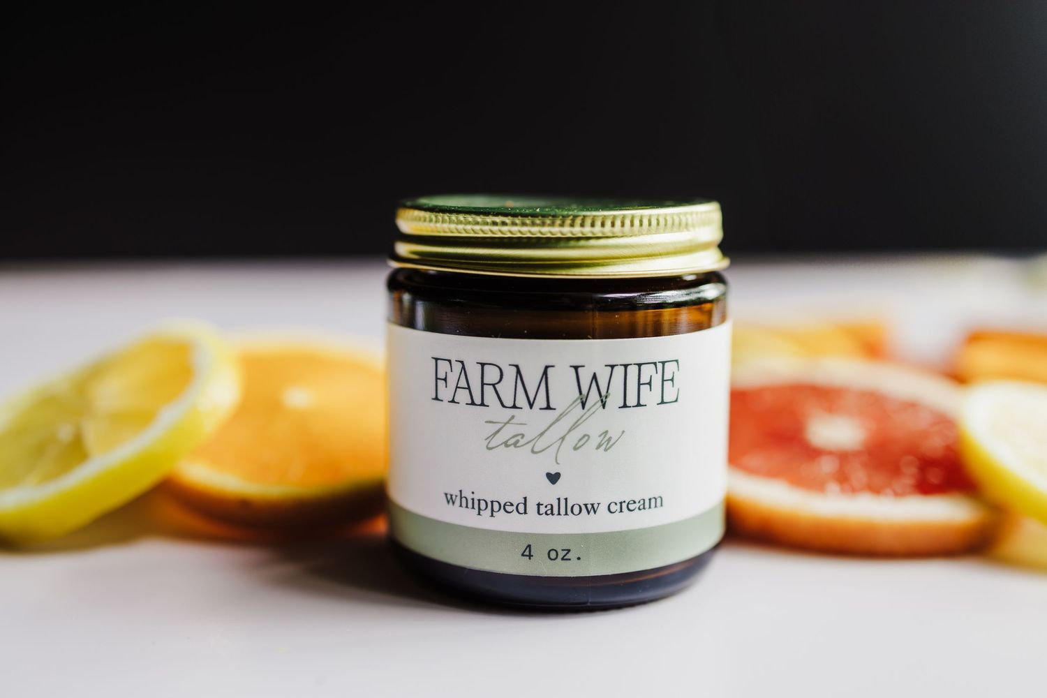 Eco-friendly and sustainable skincare products with fresh citrus fruits and farm-grown ingredients displayed on a dark surface.