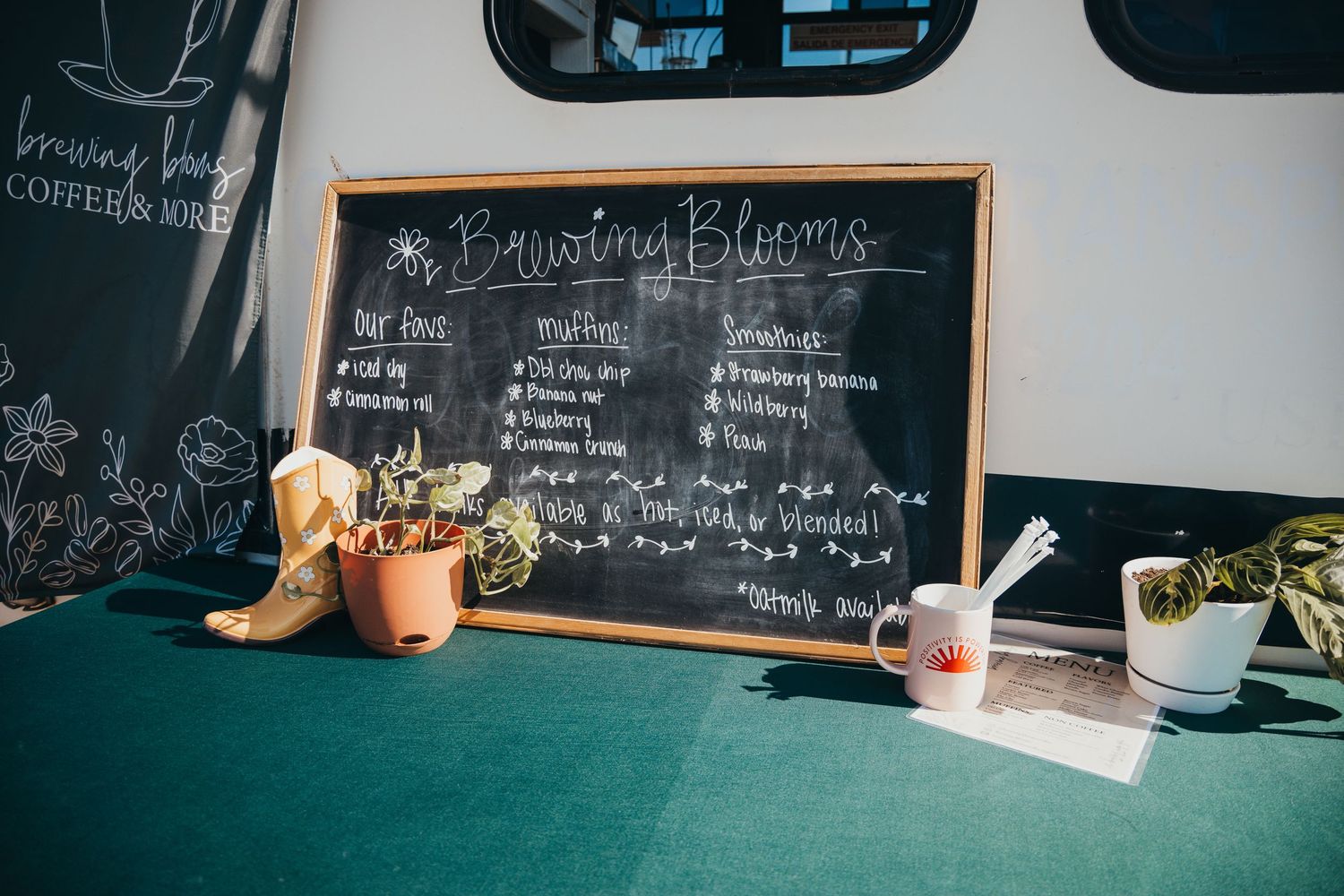 Empty cafe interior with chalkboard menus and sunlight streaming through windows.