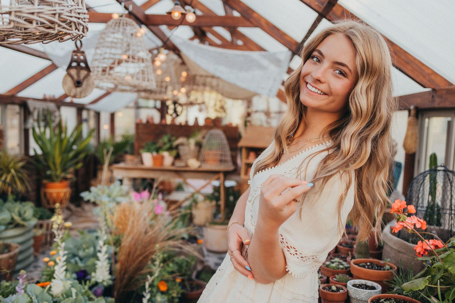 Sun-filled greenhouse with decorative plants and pottery displayed on wooden shelves.
