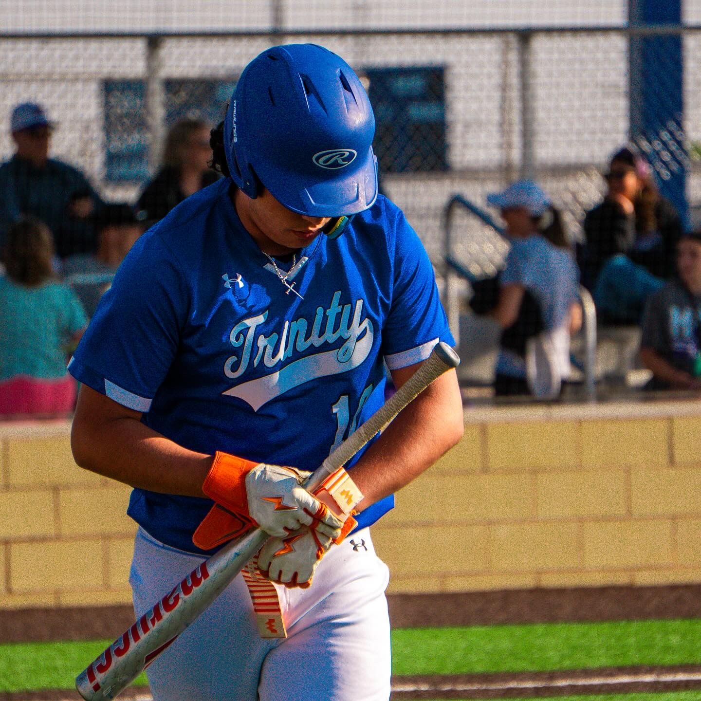 Baseball player in blue uniform preparing to bat during a game.