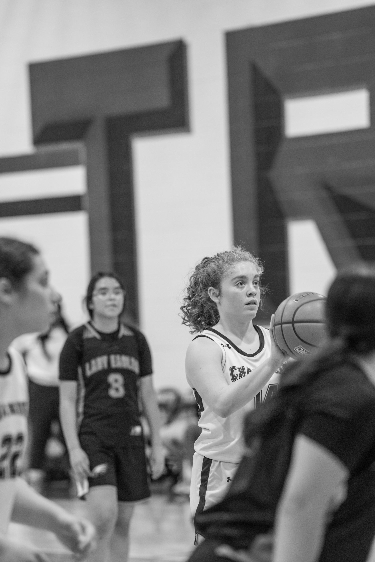 Basketball players in black and white uniforms compete during an intense game on the court.