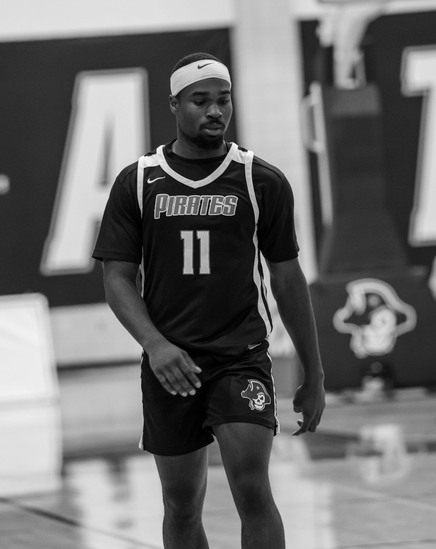 A sequence of black and white basketball training photos showing players practicing dribbling drills in a gym.
