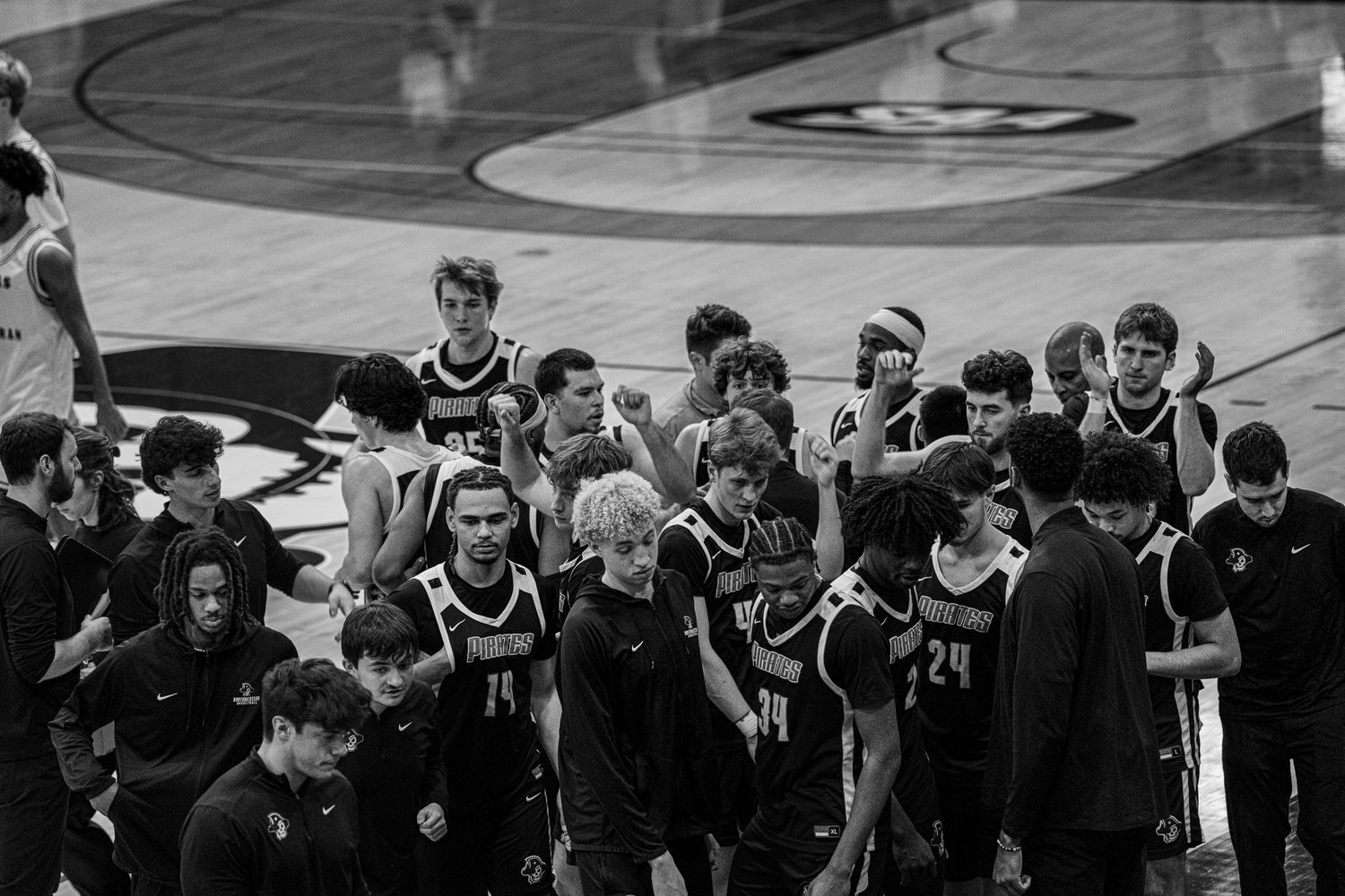 A black and white panoramic photo shows a large crowd of basketball players and spectators gathered in a gymnasium.