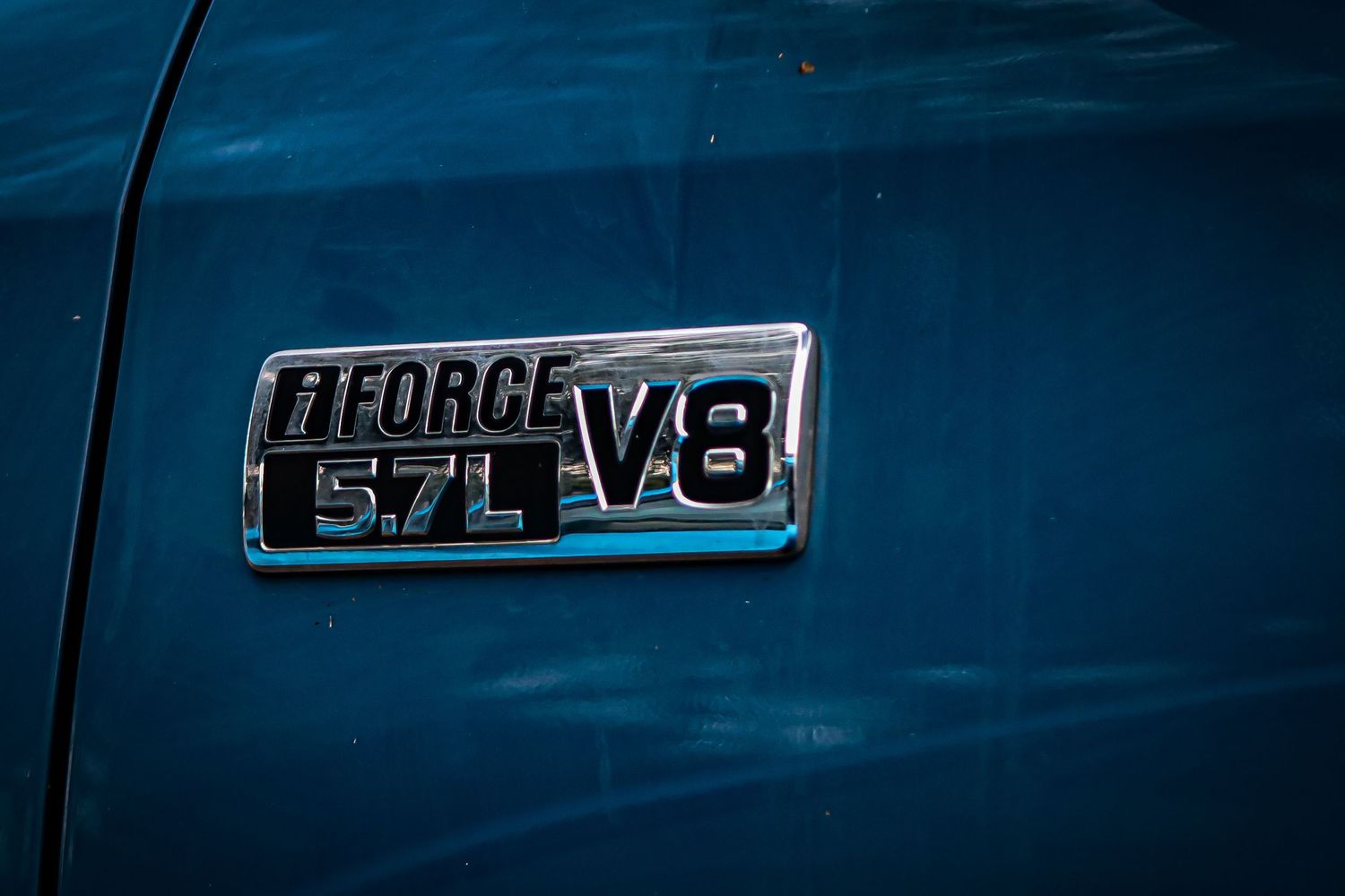 Badge detail showing 5.7L V8 engine emblem on blue vehicle exterior.