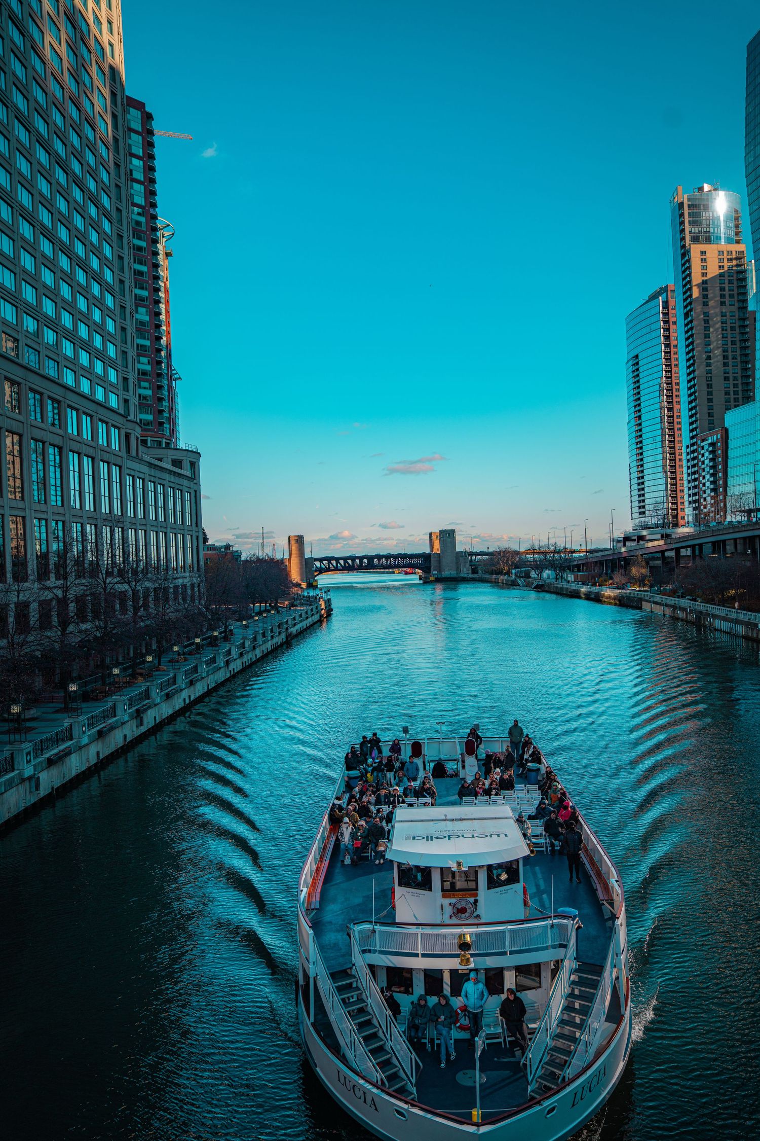 A sequence of photos showing a tour boat cruising along a waterfront with high-rise buildings against a blue sky.