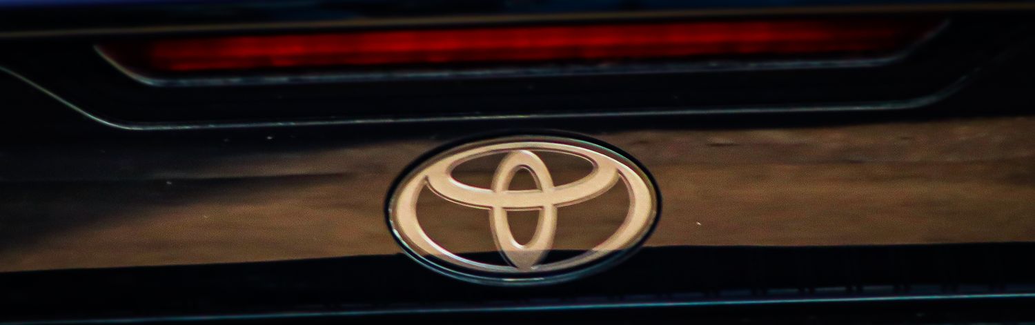 Illuminated Toyota logo on dark vehicle exterior.