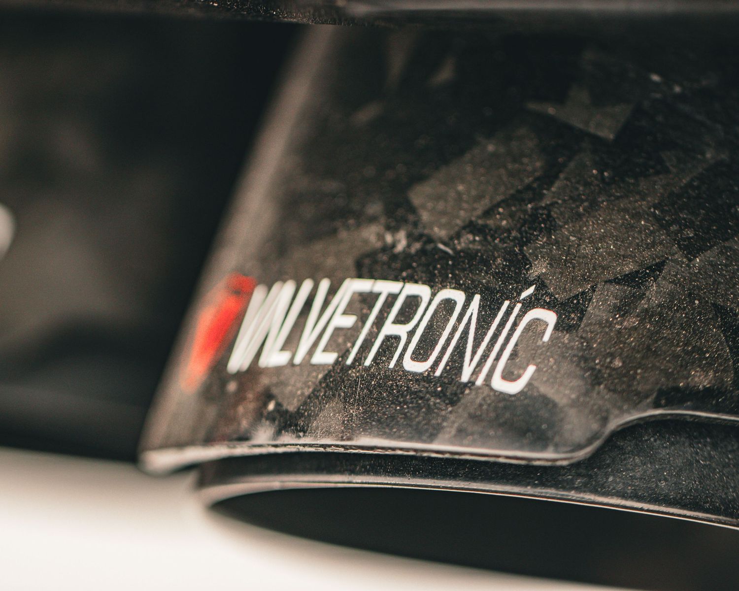 Close-up of Miletronic text branding on dirty black surface.