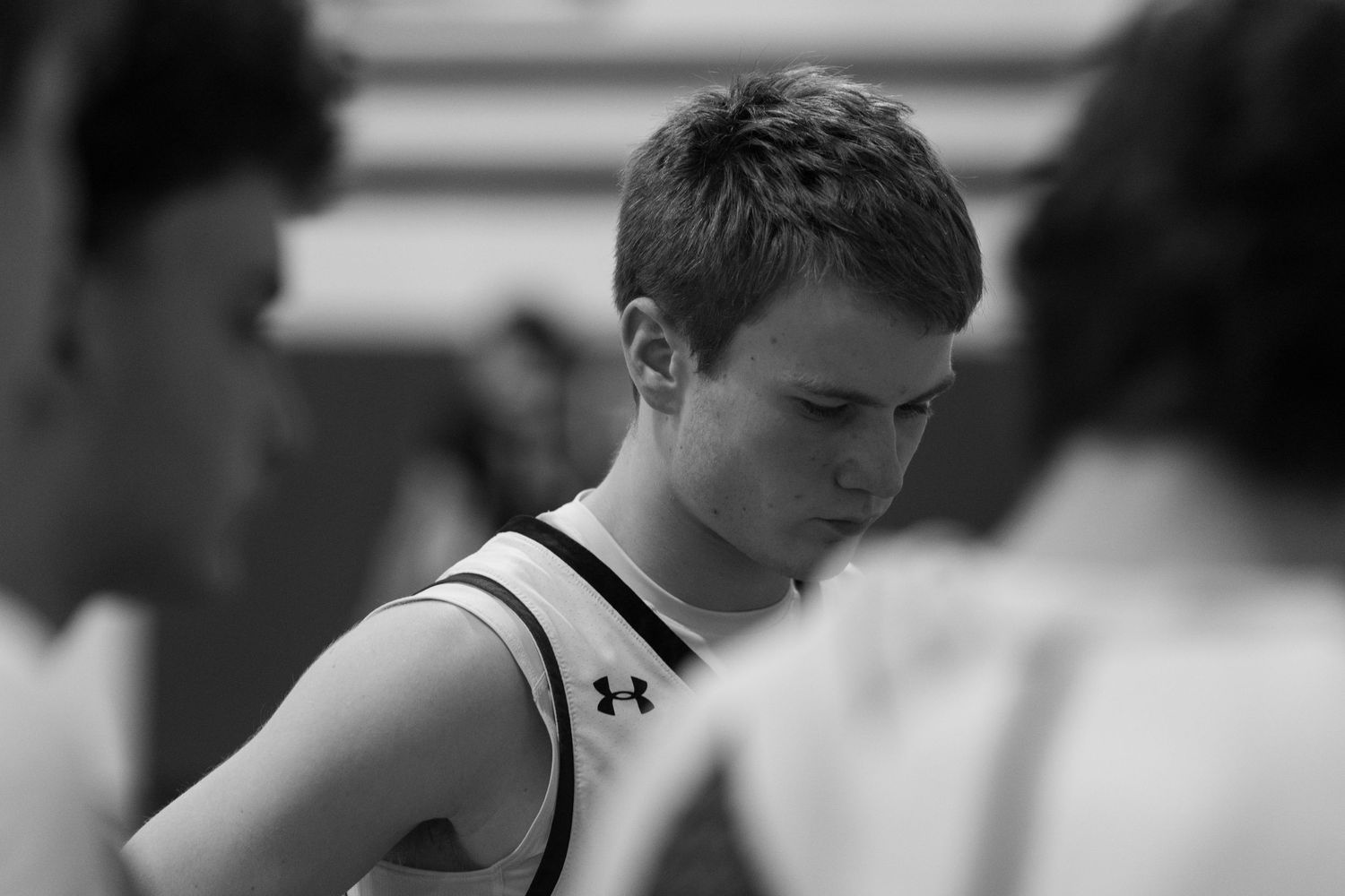 Black and white image of a high school wrestling match with two athletes competing on the mat.