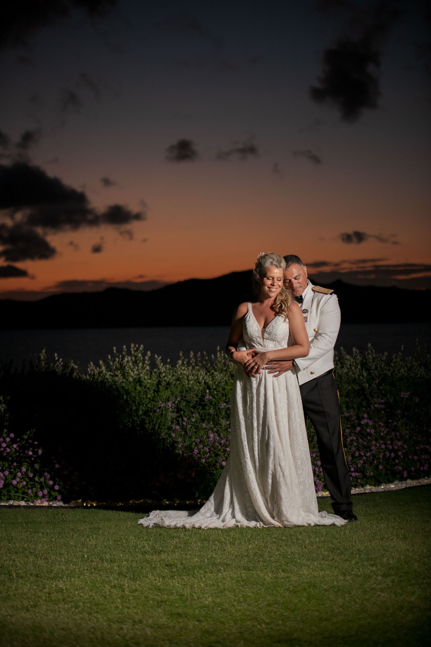 Couple shares an intimate moment in a garden during golden hour sunset wedding photo shoot.