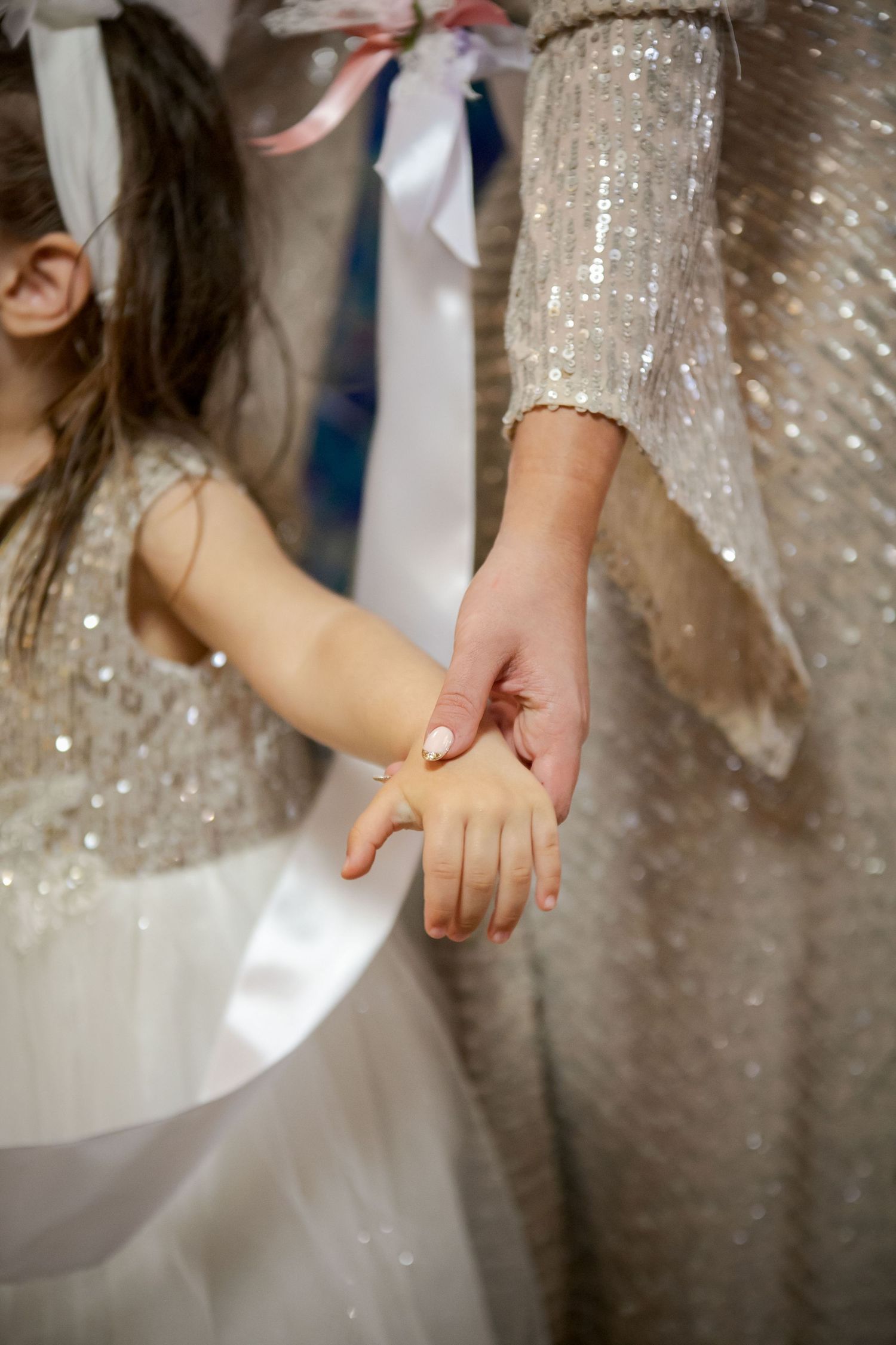 Hands touching sparkly sequined fabric in elegant detail shot.