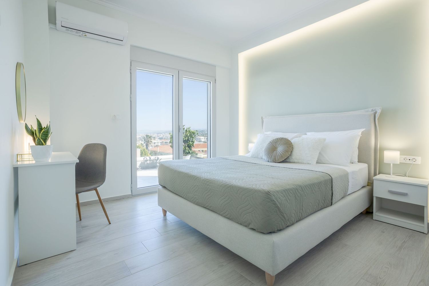 A modern all-white bedroom with recessed LED lighting features clean lines and minimalist decor throughout the space.