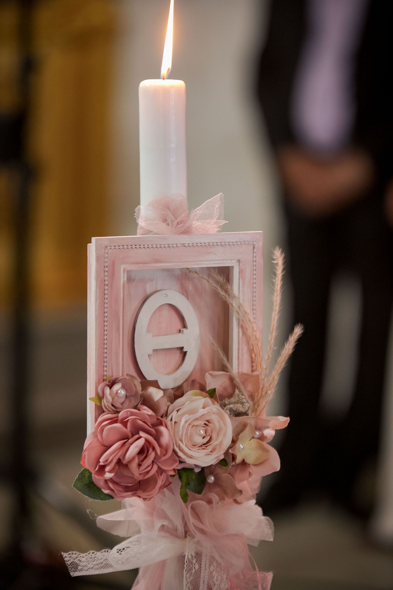 Decorative pink candle holder with roses and lace details for wedding decor.