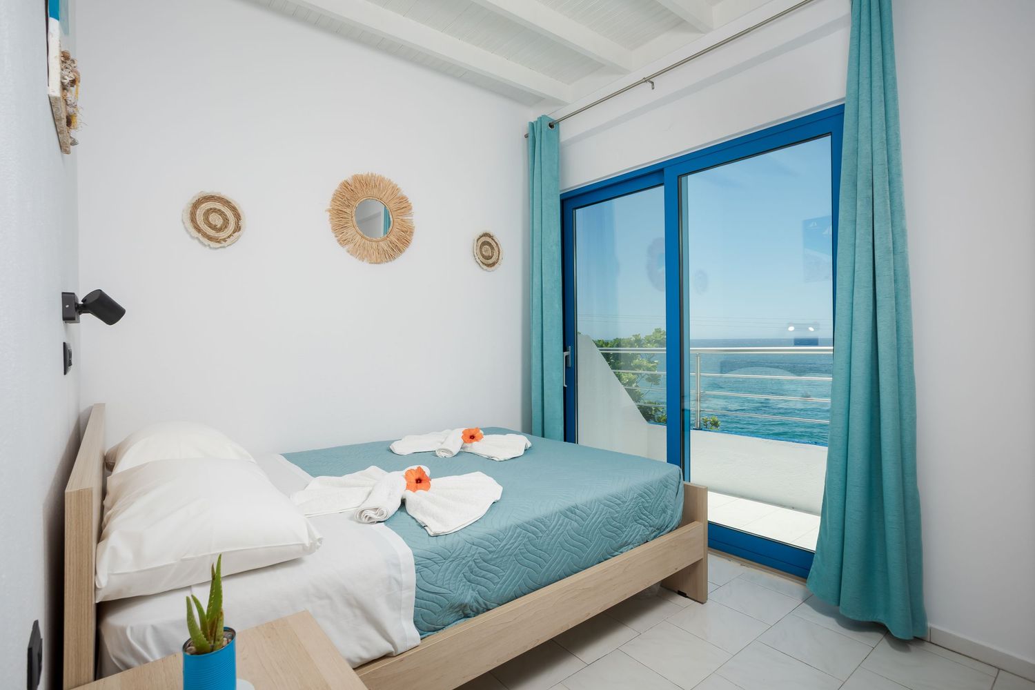 Coastal-themed bedroom with turquoise accents and ocean view windows.