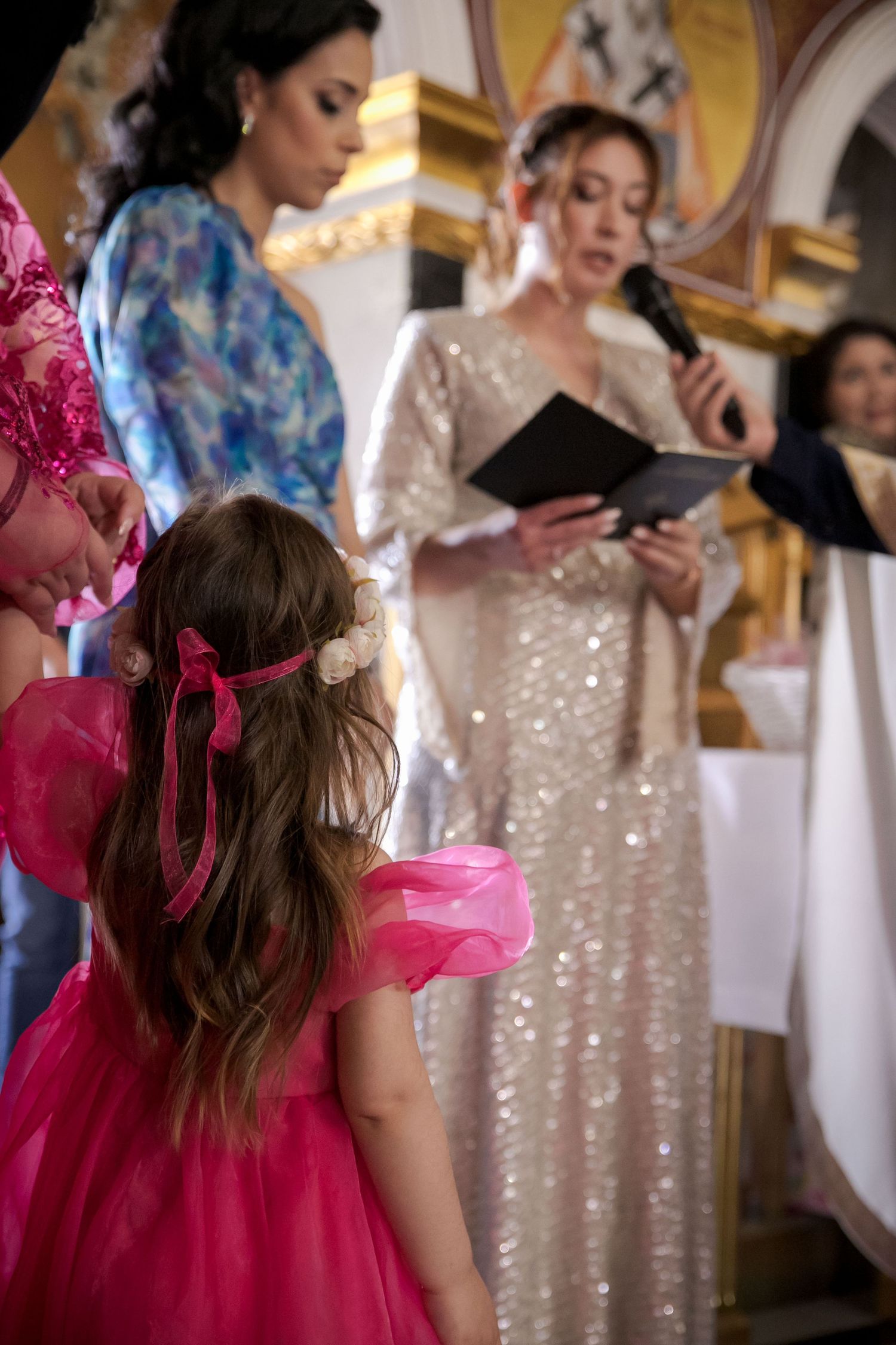 Guests in colorful formal attire at an elegant indoor event.