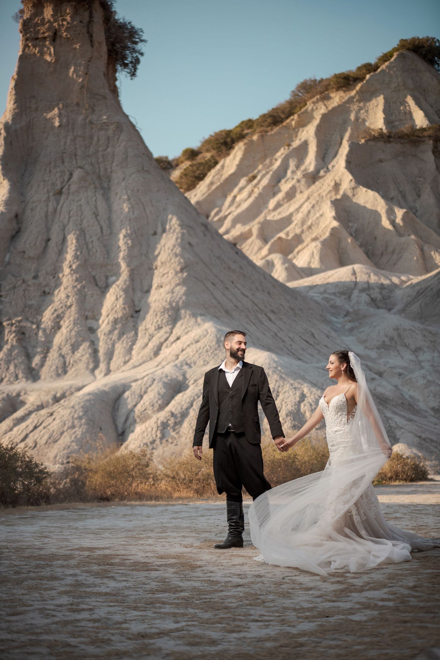 Dramatic wedding photos at white chalk cliffs with flowing bridal veil catching the wind.
